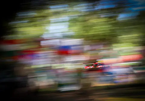 Immagine astratta di una vettura da corsa ridotta a scie di colore dal panning