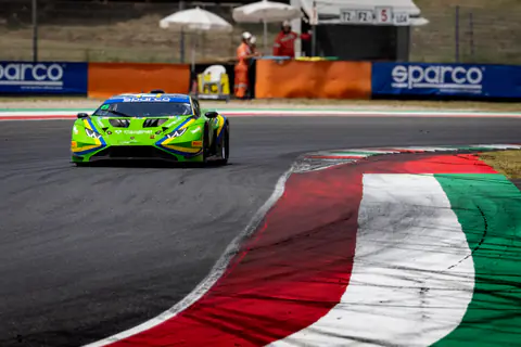Lamborghini Huracán GT3 verde in uscita di curva sui cordoli rossi e bianchi