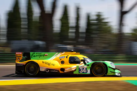 Prototipo LMP giallo e verde in velocità con gli alberi mossi sullo sfondo