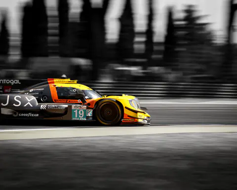 Prototipo LMP2 giallo e arancione in velocità, sfondo completamente mosso