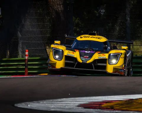 Prototipo LMP giallo con fari accesi affronta una curva in staccata